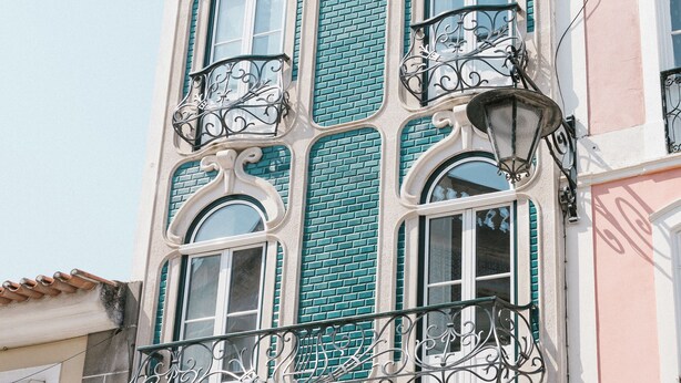 A building with a distinctive architectural style, featuring ornate balconies and a patterned facade. - Good Old Days (Caldas da Rainha)