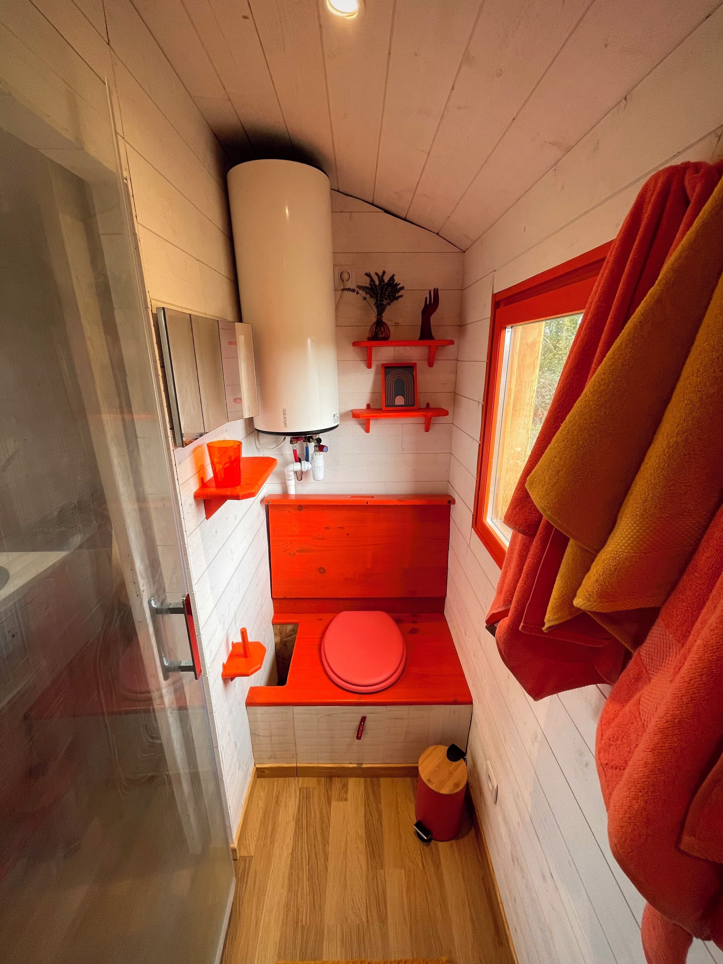 Un baño pequeño con inodoro, lavamanos y zona de ducha.