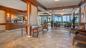 A spacious lobby with a reception desk, comfortable seating, and a large window offering a view of the outdoors. - Oceanfront Studio at Lahaina Shores #313 (Lahaina)