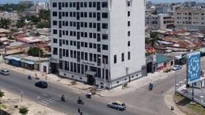 Ένα πολυώροφο κτίριο με επίπεδη πρόσοψη και μια σειρά από παράθυρα.
