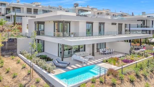 A modern multi-story residential building with a rooftop terrace, a swimming pool, and a landscaped garden. - Villa Soul (Marbella)