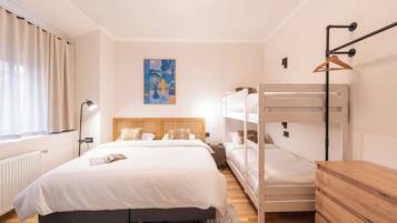 Un dormitorio con una cama litera, una mesita de noche, una lámpara y un cuadro en la pared.