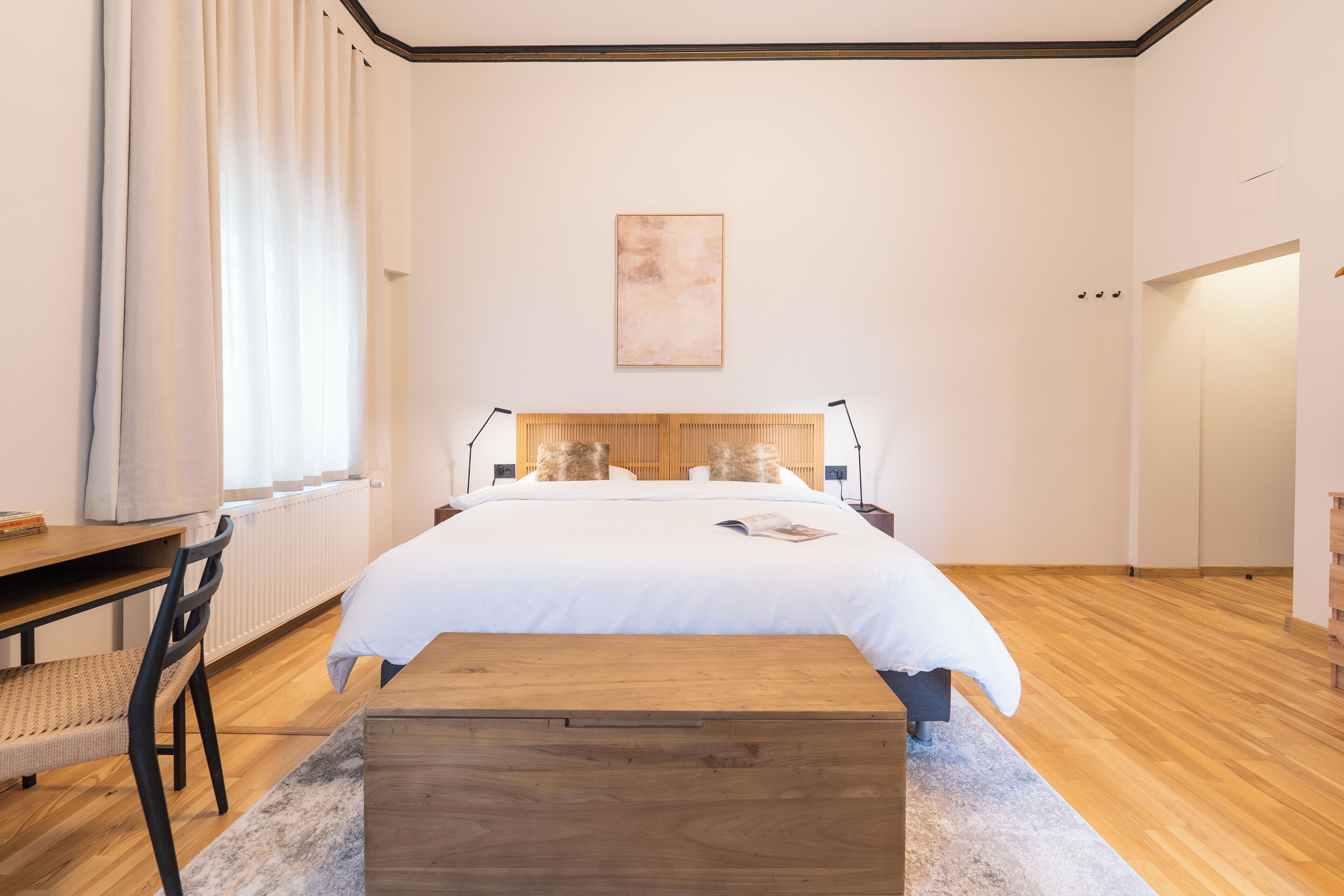 Un dormitorio con cama de madera, un escritorio y una silla.