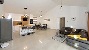 Een moderne woonruimte met keuken, eethoek en een zithoek.