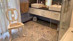 A bathroom with two sinks, a mirror, a towel rack, and a patterned floor.