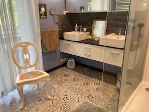 A bathroom with two sinks, a mirror, a towel rack, and a patterned floor. - Guesthouse La Rambleur with Shared Heated Pool in La Teste-de-Buch (La Teste-de-Buch)
