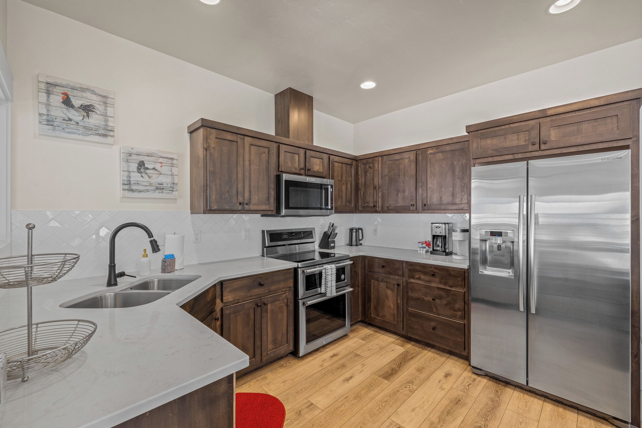 A modern kitchen with wooden cabinets, stainless steel appliances, and a two-basin sink.