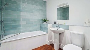 Ein Badezimmer mit einer Badewanne, einem Waschbecken und einer Toilette.