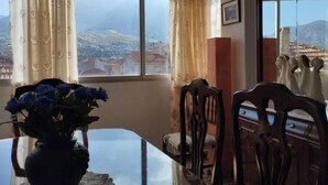 Un coin repas avec une table, des chaises et un vase de fleurs.