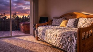 Ein Schlafzimmer mit einem großen Bett, einem Sessel und einer Schiebetür zu einem Balkon.