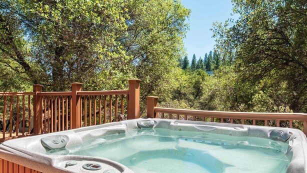 Ein Whirlpool auf einer Holterrasse mit Blick auf Bäume.