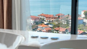 A view from a hotel room window overlooking a coastal town with houses and a body of water.