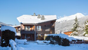 A wooden chalet with a sloped roof, surrounded by snow-covered trees and mountains. - Simply Morzine - Apartment le Sautaillet (Morzine)