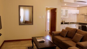 Una sala de estar con un sofá marrón, una mesa de centro y un cuadro enmarcado en la pared.