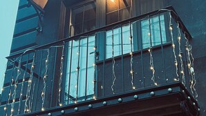 Un edificio con un balcón decorado con luces de cadena.