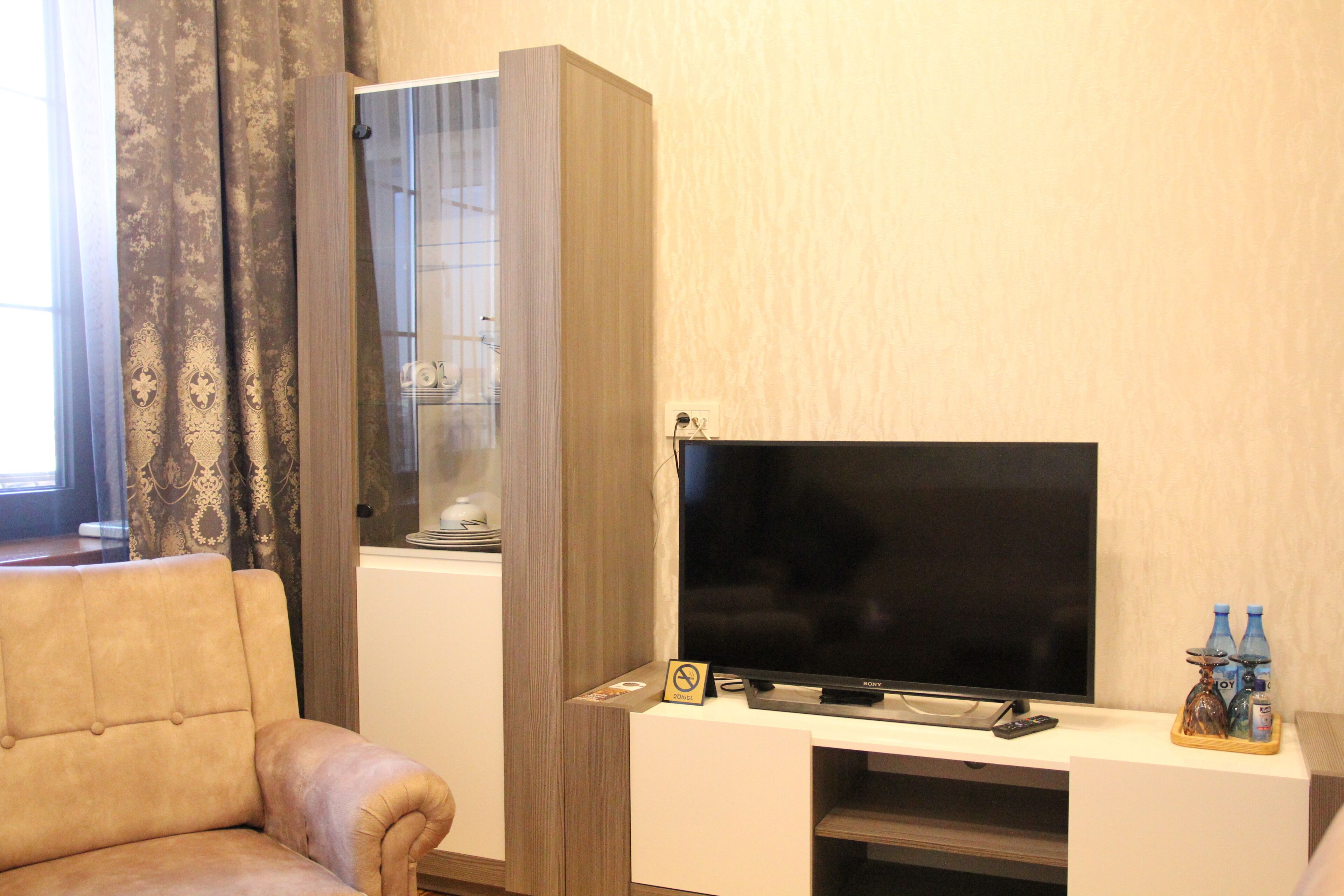 A living room with a sofa, a television, and a cabinet.
