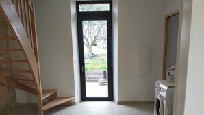A clean, modern interior with a staircase, a washing machine, and a view through a door. - . Special PMR. Near one of France's most beautiful villages. Views (Brousse)
