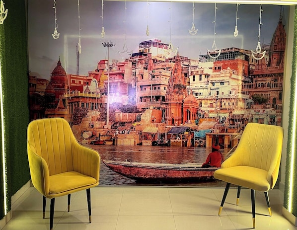 A room with two yellow armchairs facing a mural of a cityscape.