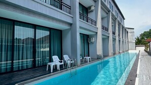 A modern hotel with a swimming pool, multiple balconies, and outdoor seating. - HF Ville (Surat Thani)