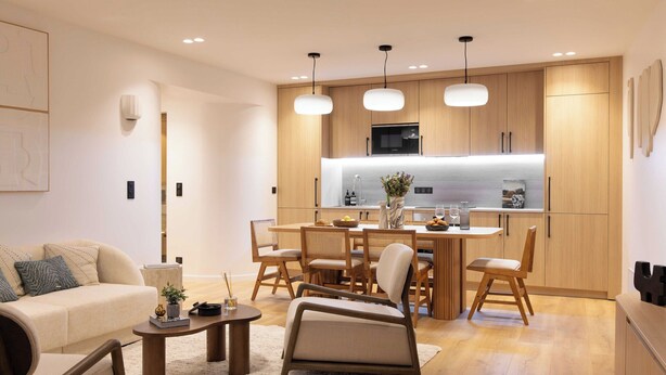 A modern living room with a sofa, coffee table, and dining area with wooden chairs and a table. - Elegant Apartment With AC - 3br-6p- Montorgueil (Paris)