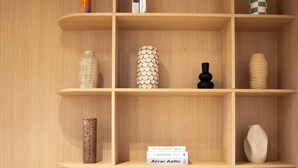 A wooden shelving unit with various decorative items and a book titled "Alvar Aalto". - Elegant Apartment With AC - 3br-6p- Montorgueil (Paris)