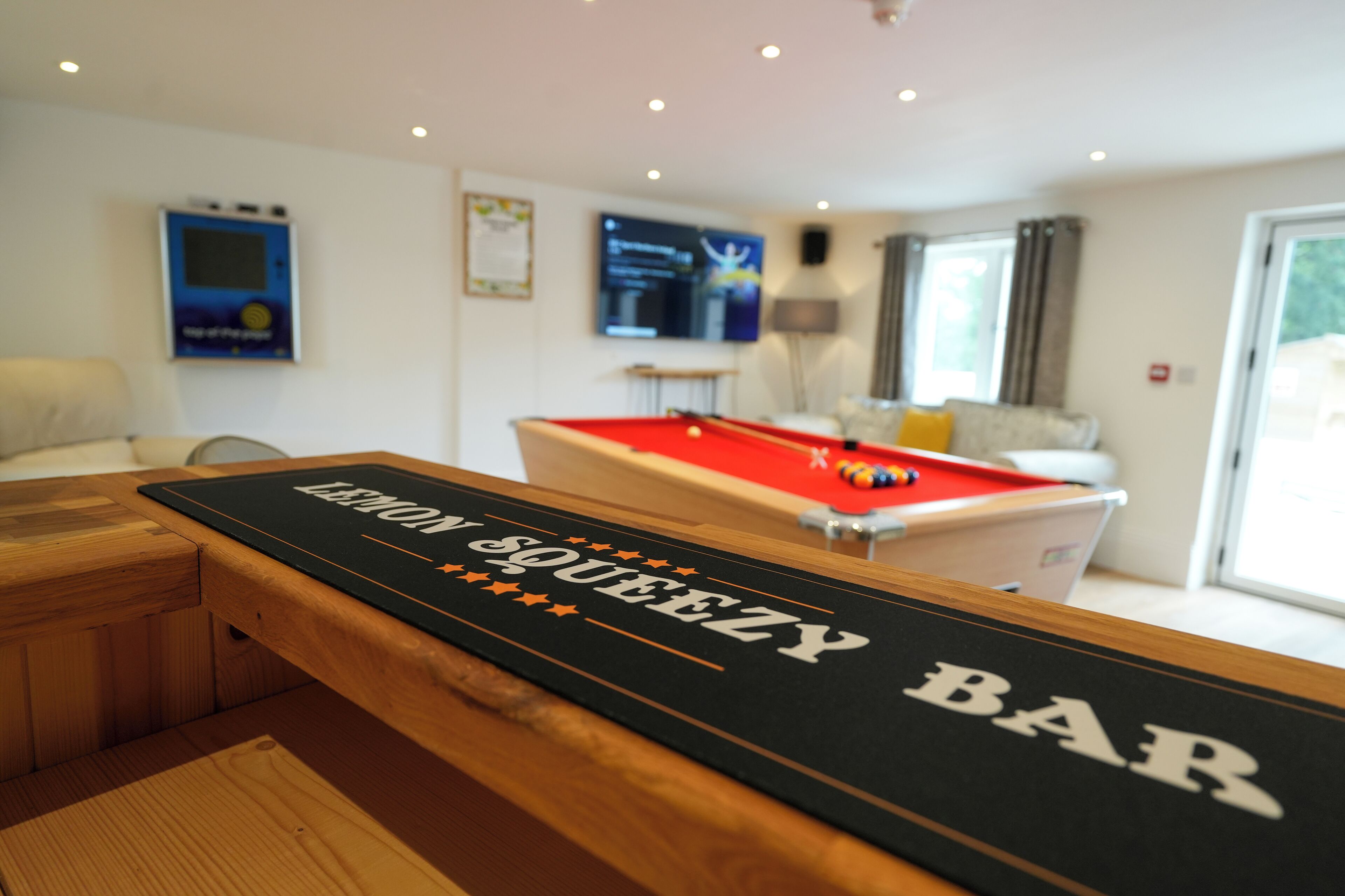 Ein Billardtisch mit der Aufschrift 'Lemon Squeezy Bar', ein Billardqueue und ein Billardkugeln.