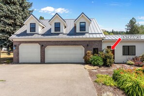 A two-story house with a garage, a driveway, and a landscaped garden. - New Listing! Hayden Lake Guest House | Private Balcony & Lake Views (Hayden)