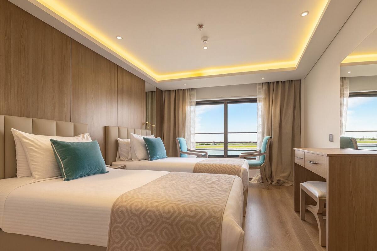 Una habitación de hotel con dos camas, un escritorio y una silla.