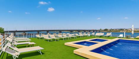 Piscina a l'aire lliure, para-sols i gandules