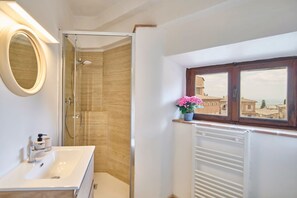 Une salle de bain équipée d’une douche, d’un lavabo, d’un miroir, d’une fenêtre avec vue et d’un radiateur.