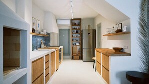 A modern kitchen with wooden cabinets, a built-in oven, and a refrigerator. - Authentic 4 bedroom stone house, situated in the very heart of old Komiza town (Komiža)