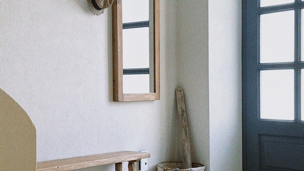 A room with a wooden bench, a mirror, a fish decoration, a hat, and a door. - Authentic 4 bedroom stone house, situated in the very heart of old Komiza town (Komiža)