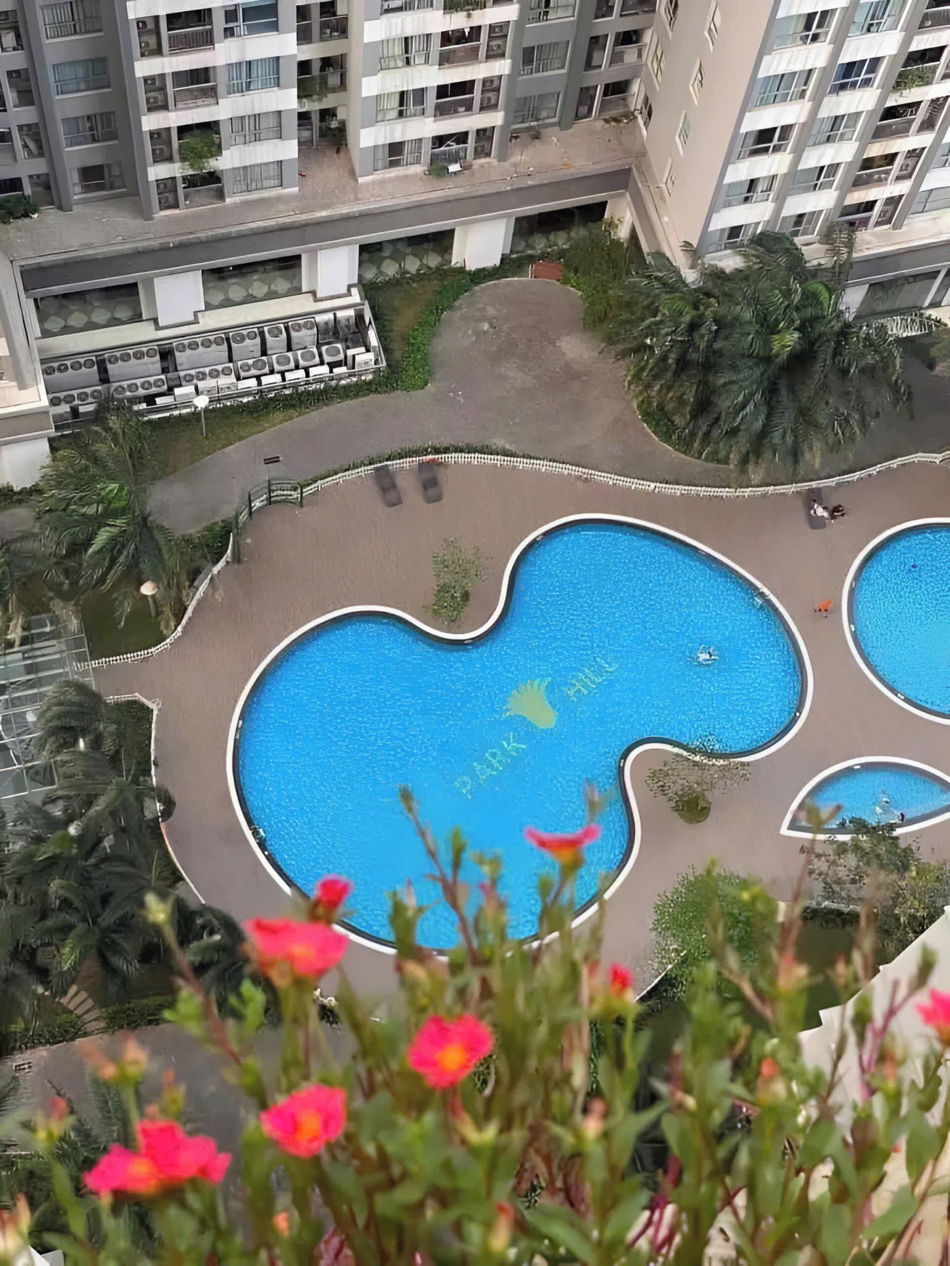 A residential building with multiple balconies and a central swimming pool area.