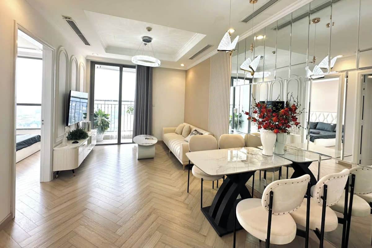 Ein modernes Hotelzimmer mit Essbereich, einer Couch und einem Balkon mit Blick.