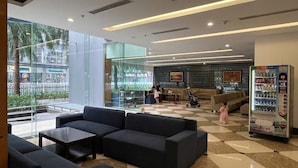 A modern lobby with a checkered floor, seating area, and vending machine. - Dani Apartment - Times City - Ha Noi (Hanoi)