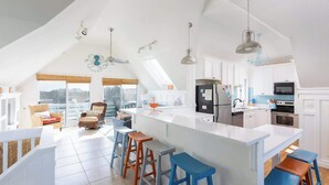 A spacious kitchen with a large island, modern appliances, and a view to the outside. - Walk to Duck Soundfront w Pool, Firepit, Cornhole (Kitty Hawk)