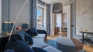 A modern living room with a sofa, a coffee table, and a lamp. There is a view of a cityscape through a window. - Piazza della Signoria - Two bedroom  Firenze luxury (Firenze)