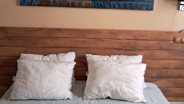A bed with two white pillows and a textured blanket, a wooden headboard, and a painting of pottery on the wall. - Athenian Stay 301 By VPN (Athens)