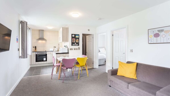 A modern apartment with a kitchen, dining area, and living room.