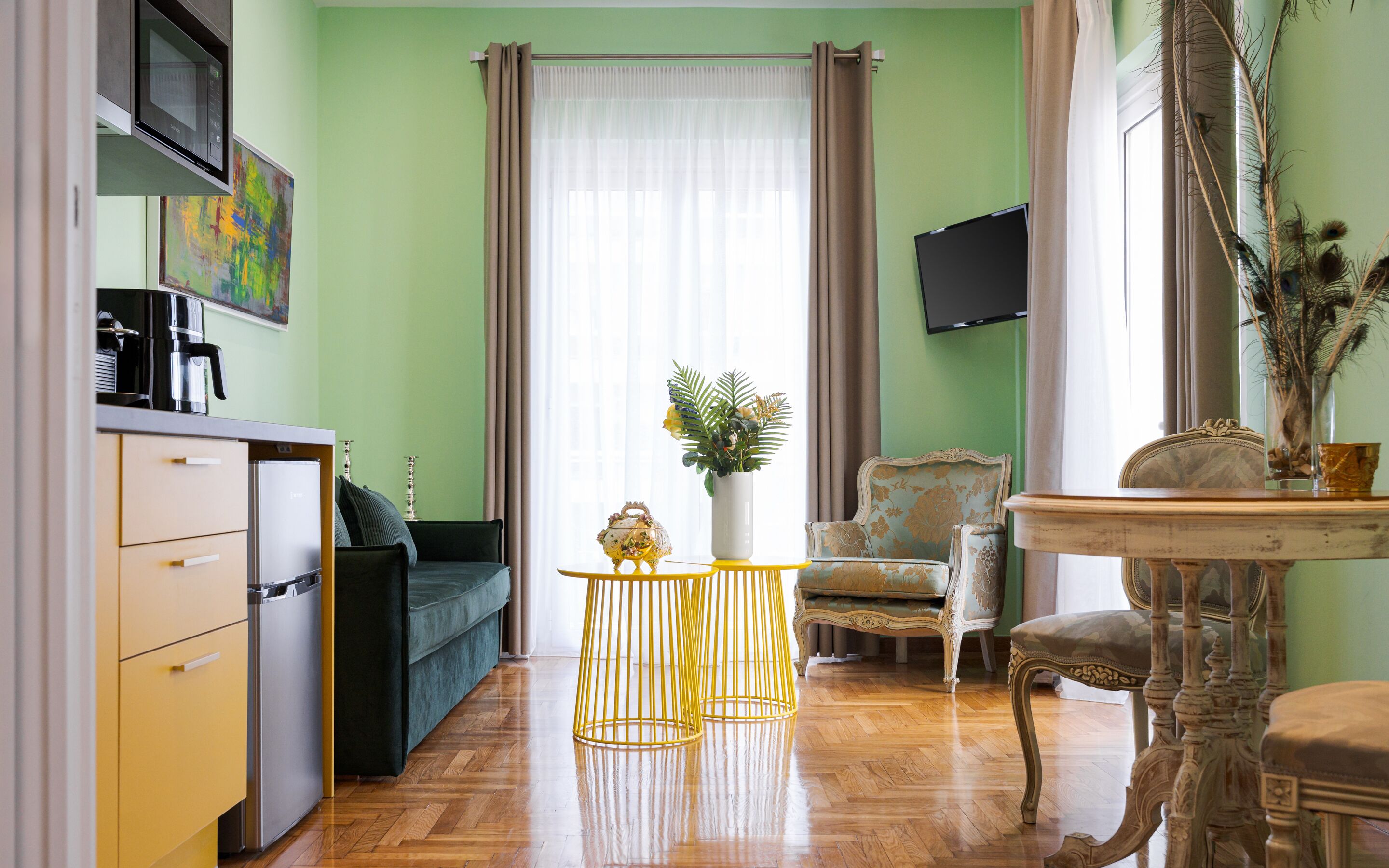 A living room with a sofa, a coffee table, a TV, and a dining table.