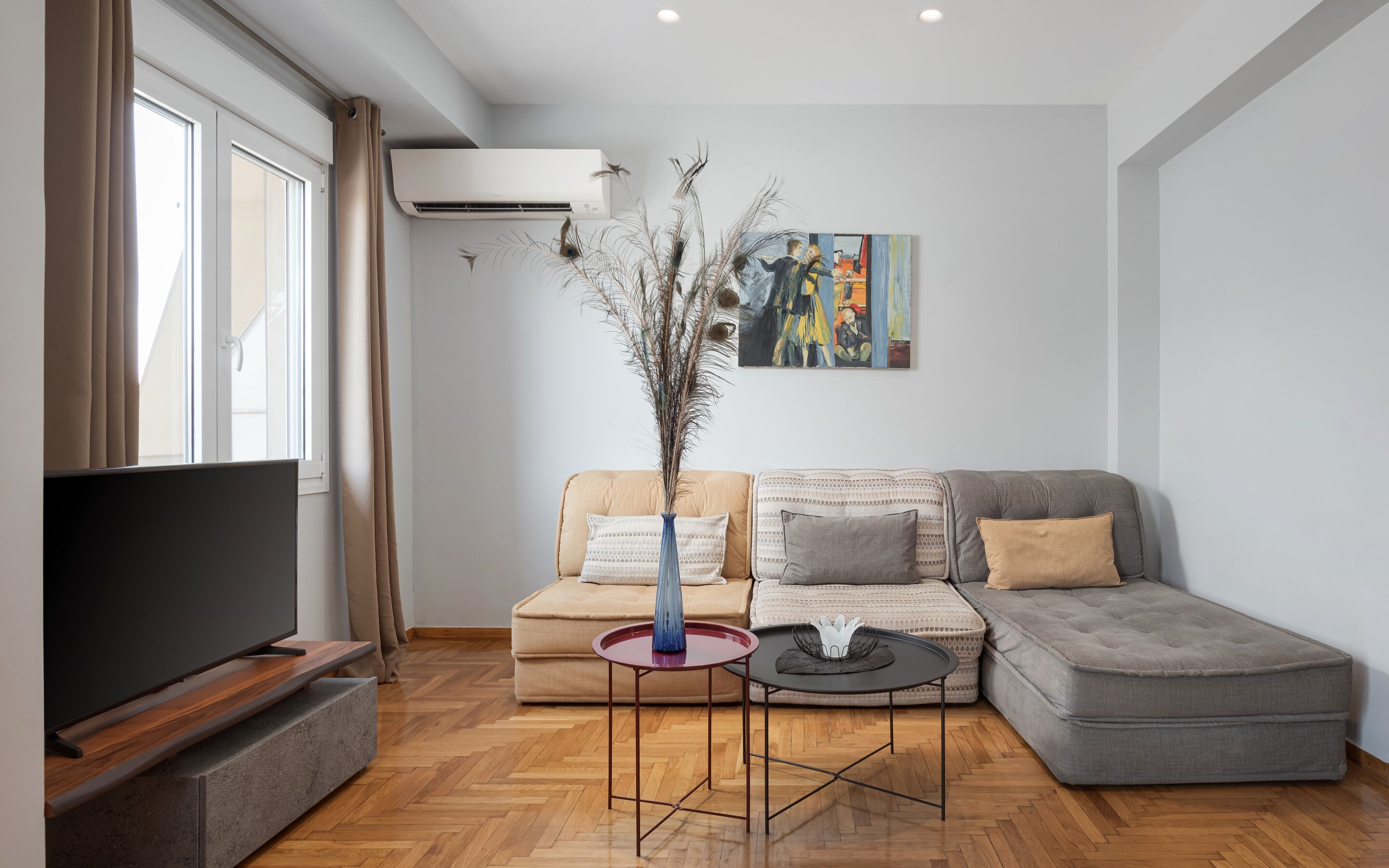 A modern living room with a grey sofa, a coffee table, and a flat-screen TV.