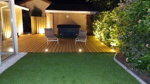 A patio with a barbecue grill, two chairs, and a small lawn area. - An enchanting haven of calm (Andernos-les-Bains)