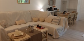 Una sala acogedora con un sofá, una mesa de centro y una mesa de comedor con sillas.