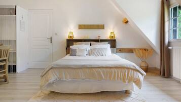 Une chambre à coucher avec un lit, une table de chevet, une lampe, une fenêtre et une porte.
