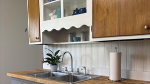 A kitchen with a wooden countertop, stainless steel appliances, and white cabinetry. - Stadium Stroll | Walk to IU Football | Sleeps 14 (Bloomington)