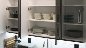 Cozinha com armários abertos, torradeira e pia.