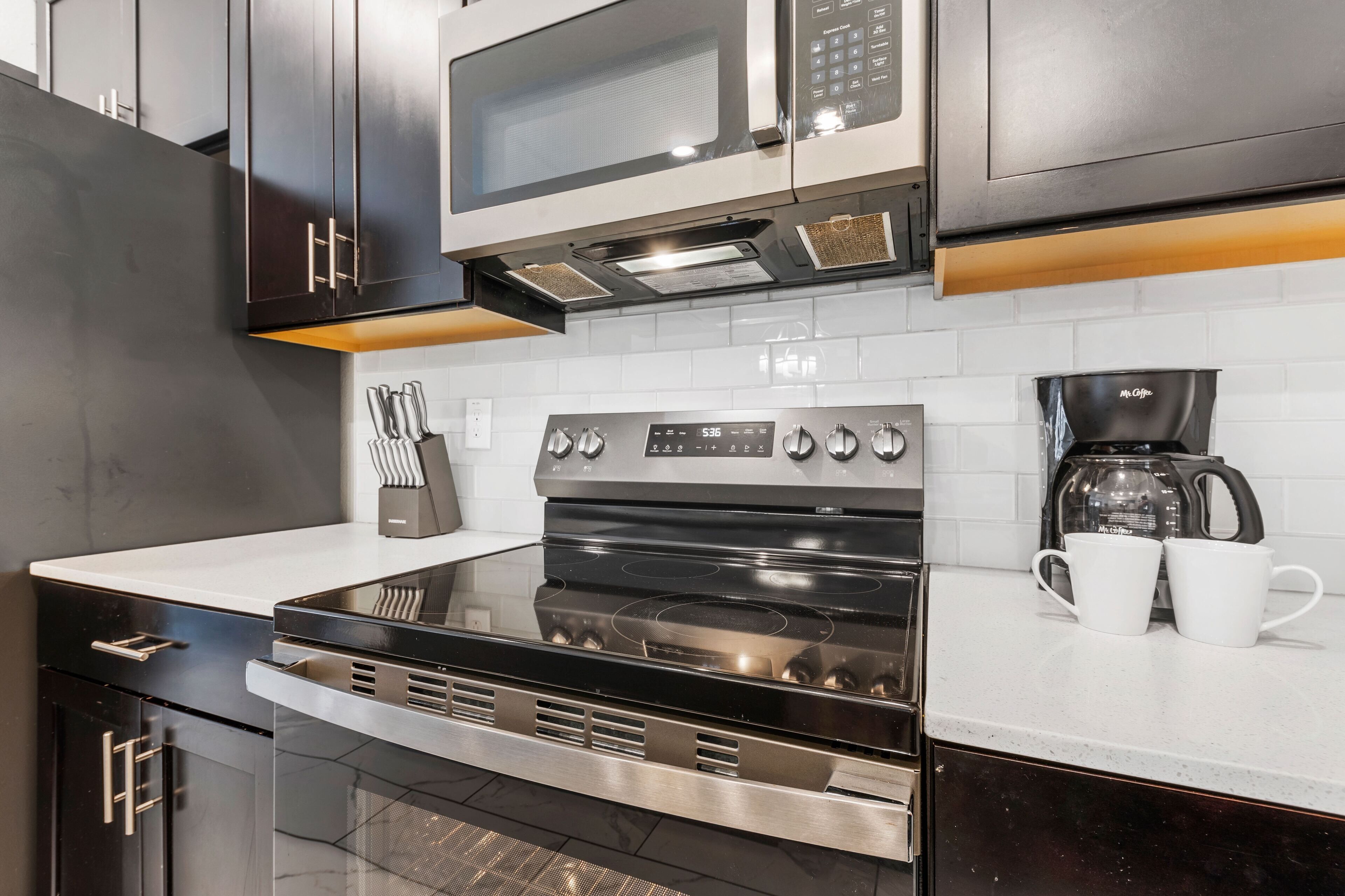 A modern kitchen with stainless steel appliances, a microwave, and a coffee maker.