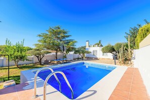 A swimming pool with a clear blue water, surrounded by a white wall and a tiled patio. - Golf • Mas Vilet - Unik Vacation (El Catllar)