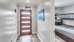 A hallway with a wooden door, a painting, and a bunk bed in a room. - Walkable Apt 2 Mi to Dtwn: Houston Retreat! (Houston)
