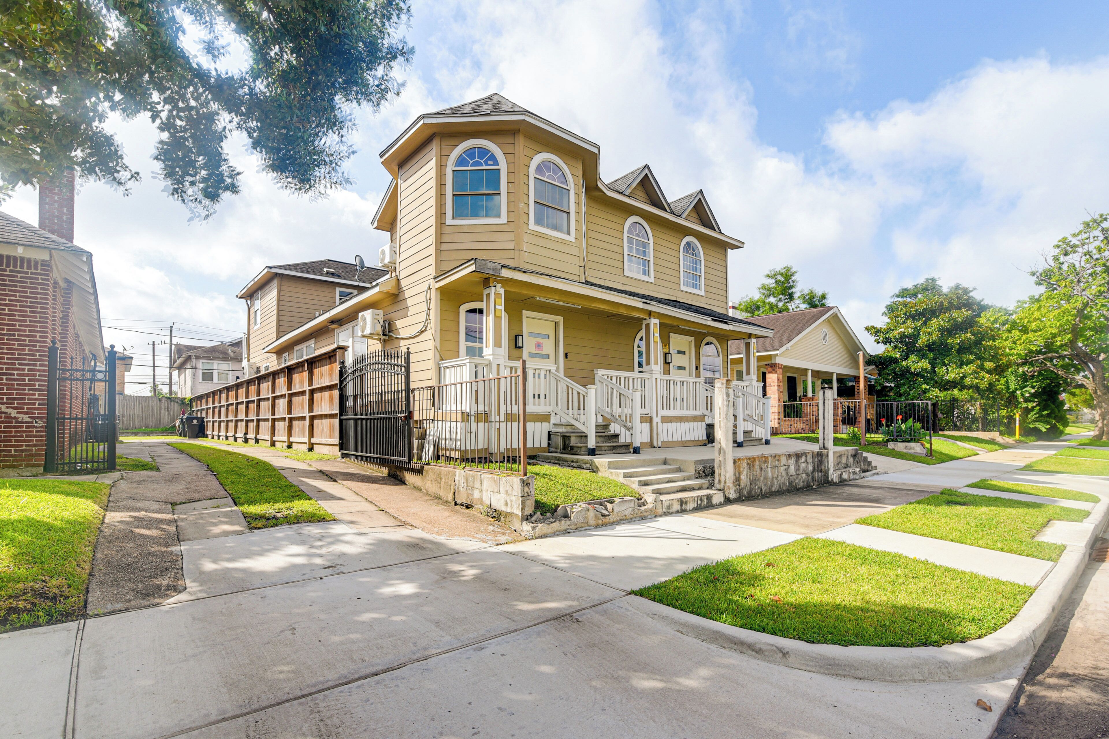 A two-story residential house with a front porch, a garage, and a well-maintained lawn.